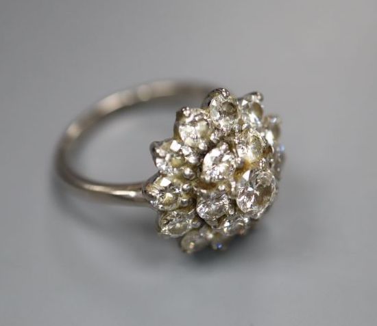 A white metal (stamped 18ct) and domed diamond cluster ring, size J, gross 4.7 grams.